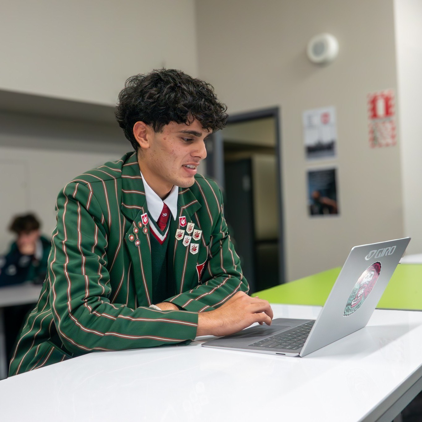 A Year 13 student building his business plan at a laptop